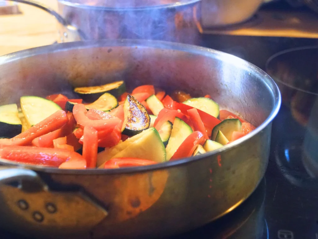 Frühlingsnudelsalat Zucchini und Paprika in einer Pfanne aus Kupfer