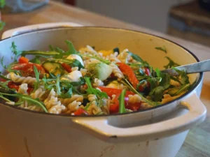 Bunter Nudelsalat mit Frühlingsgemüse und Kräutern, angerichtet in einer Schüssel – leicht vorzubereiten, perfekt für Mahlzeiten im Grünen.