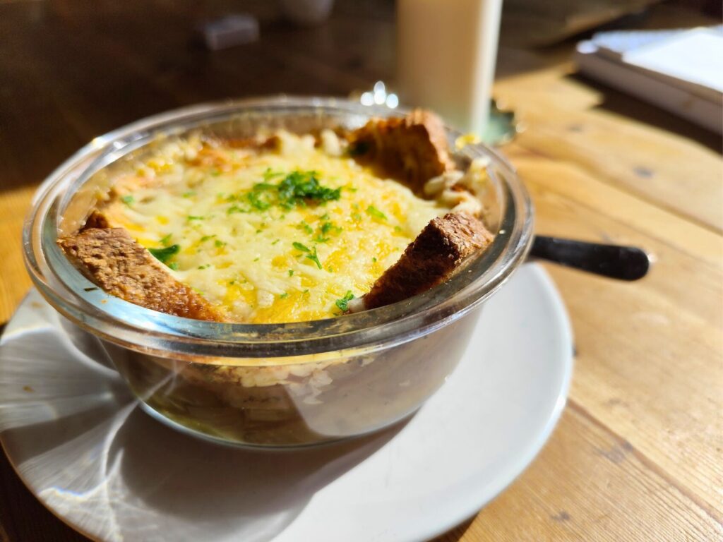 Hausgemachte Zwiebelsuppe mit Käse überbacken, serviert im Glas