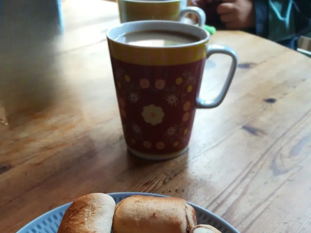 Kaffe in einem Becher mit floralem Volkskunst motiv auf einem Holztisch