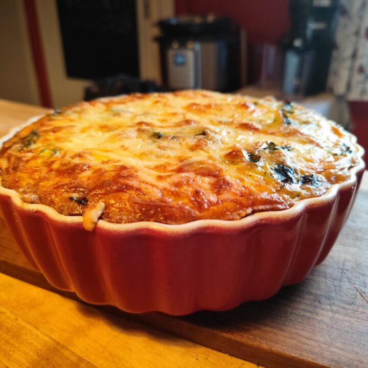 quiche mit Mangold oder Spinat auf einem Holzbrett